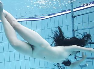 Seductive raven-haired minx swims in the pool completely naked