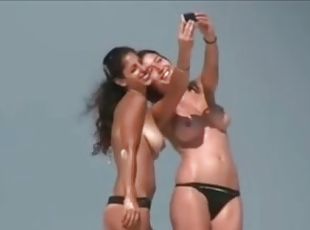 Topless amateur brunette babes get caught on voyeur's cam on a beach