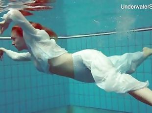 Elegant redhead goes swimming in her sexy clothes