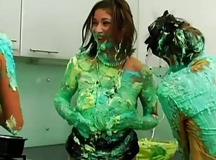 All girl food fight with green frosting covering them