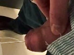Man unzips his pants pissing in office toilet and shows his wet cock close to camera
